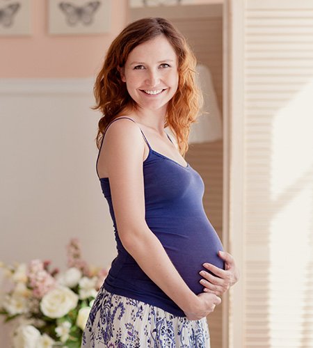 Pregnant Woman in Blue Top looking at Camera